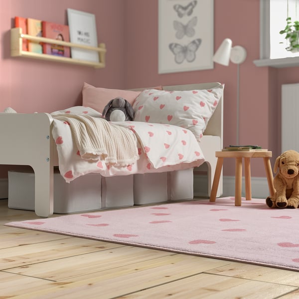 Habitación infantil con alfombra BARNDRÖM rosa, diseño de corazones, grande, suave y ecológica, debajo de una cama pequeña.