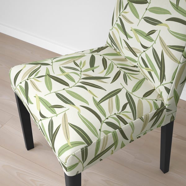 Silla con estampado de hojas con patas y cojines de madera.