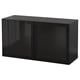 Mueble BESTÅ negro, rectangular, acabado brillante, puerta de cristal, diseño moderno.