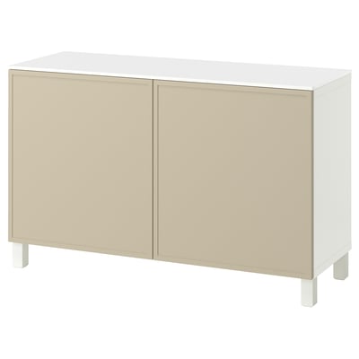 Aparador BESTÅ blanco-beige con dos puertas y patas blancas.