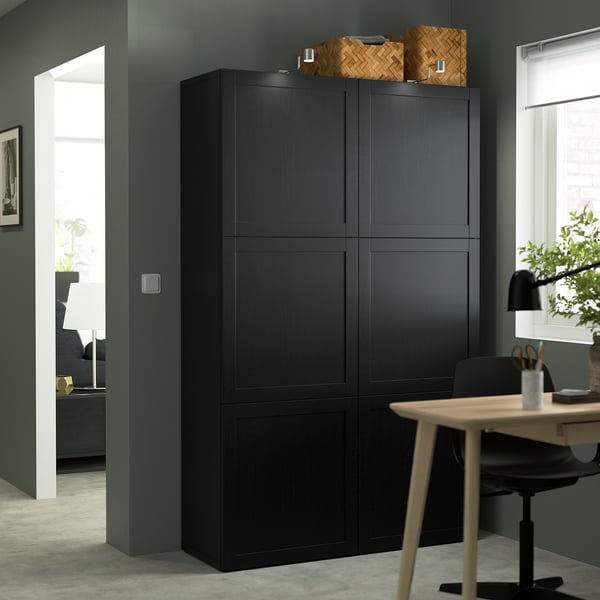 Mueble de almacenaje BESTÅ negro con 6 compartimentos en una oficina moderna.
