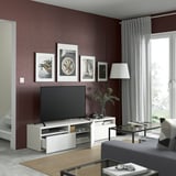 Sala de estar de color granate con televisión, decoración y mesa de café.