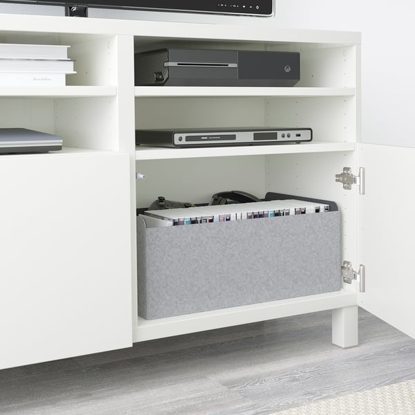 Mueble de tv blanco BESTÅ con estantes ajustables, gestión de cables y almacenamiento integrado para accesorios electrónicos y de juego.
