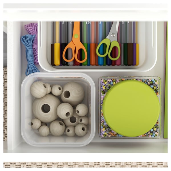 Cajón de manualidades organizado con hilo, marcadores, tijeras, cuentas de madera y una bandeja verde con cuentas pequeñas.