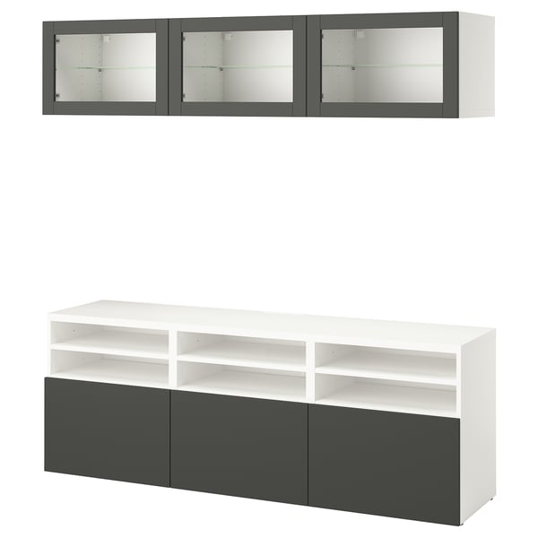 Moderno mueble de almacenaje BESTÅ en blanco con detalles en gris, con armarios de pared y un banco de televisión con estantes abiertos y cerrados.