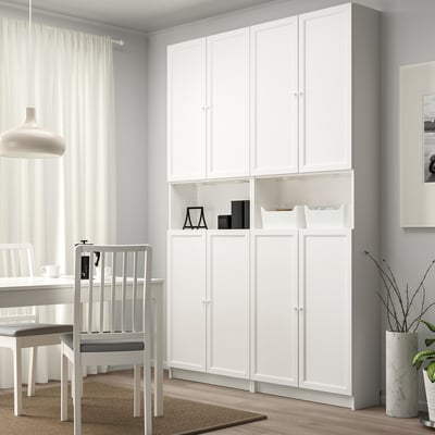Librería BILLY blanca con puertas empotradas, alta, minimalista, en zona de comedor con silla.