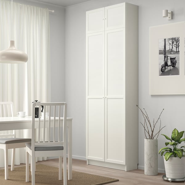 Comedor minimalista con librería Billy, mesa, sillas, plantas, foto.