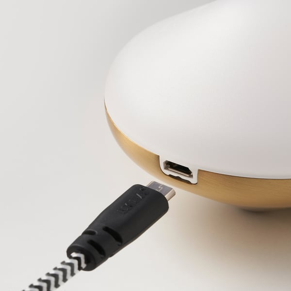Un primer plano de una pequeña y elegante luz led con un puerto USB en su parte inferior, diseñada para facilitar la carga.