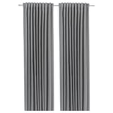 Dos cortinas grises que oscurecen la habitación cuelgan una al lado de la otra, diseñadas para bloquear la luz y proporcionar privacidad, hechas de poliéster reciclado.