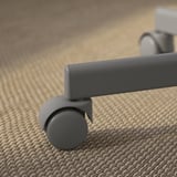 Primer plano de una silla moderna con ruedas grises, que muestra materiales robustos y ruedas suaves para facilitar el movimiento.