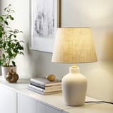 Lámpara BLIDVÄDER: cerámica crema con pantalla beige en el mueble, que aporta calidez.