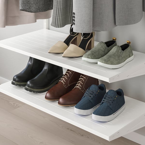 Las estanterías blancas exhiben calzado diverso: tacones, mocasines, botas y zapatillas de deporte organizadas cuidadosamente. Ideal para varias estaciones y clima.