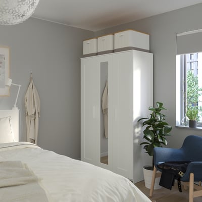 Armario blanco BRIMNES con puertas con espejos, que proporciona un amplio espacio de almacenamiento y mejora la luminosidad de la habitación.