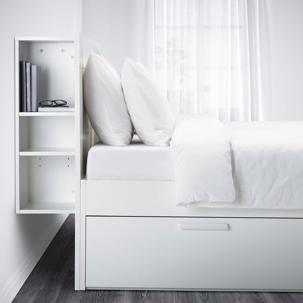 Cama BRIMNES blanca con almacenaje, cabecero, almohadas mullidas, edredón blanco, cajones ocultos, cortinas transparentes.