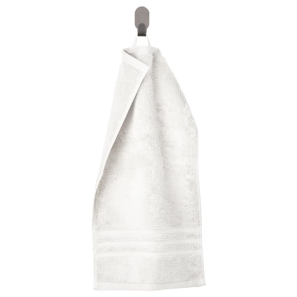 Toalla blanca BROKGLIM con cenefa tejida, colgada. Algodón orgánico suave.