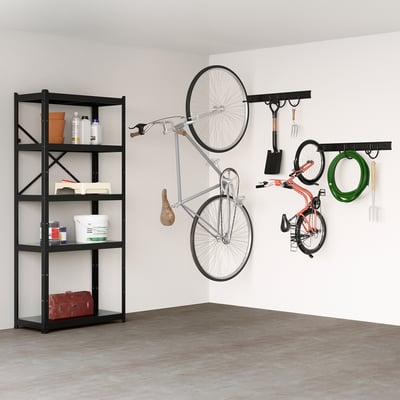 La estantería BROR negra tiene capacidad para objetos pesados como herramientas, bicicletas. Las bicicletas cuelgan de ganchos de pared junto a herramientas de jardín y mangueras.