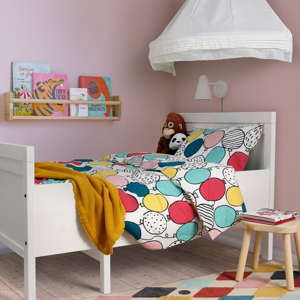 Habitación infantil con edredón BUSENKEL, almohada de mono, estantería, dosel, taburete, alfombra.