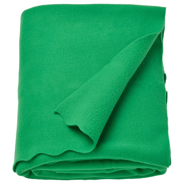 Manta polar verde, suave y acogedora, doblada cuidadosamente. Confeccionado con un 90% de poliéster reciclado.
