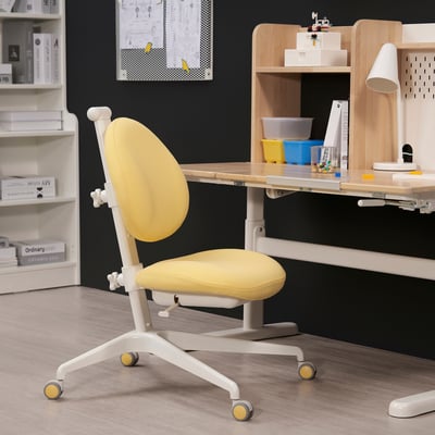 Silla DAGNAR amarilla ajustable con ruedas sobre escritorio de madera.