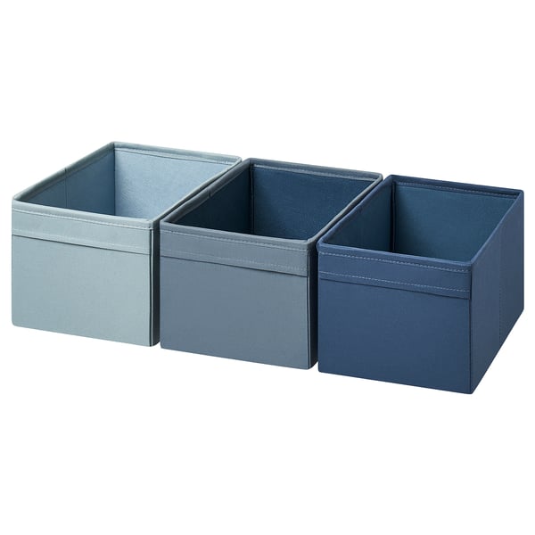 Tres cajas de almacenamiento de tela azul en tonos claros, medios y oscuros. Forma rectangular con asas de tela, apta para librerías billy.