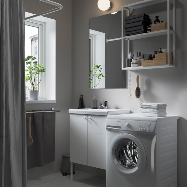 Baño gris con mueble ENHET, lavamanos, espejo y ventana.