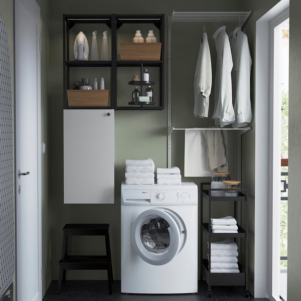 Moderno rincón de lavandería con armario ENHET blanco, estanterías y lavadora. Sostiene toallas, detergentes y ropa de forma ordenada.