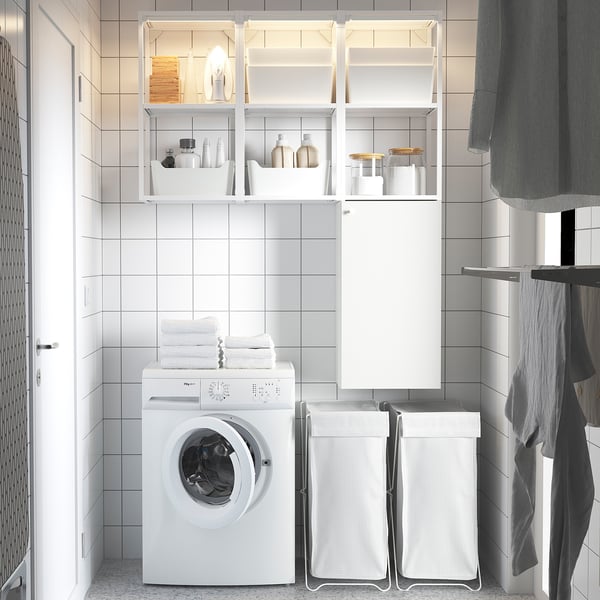 Moderno baño blanco con lavadora, almacenamiento abierto y armario de pared. Diseño limpio, fresco y que ahorra espacio.