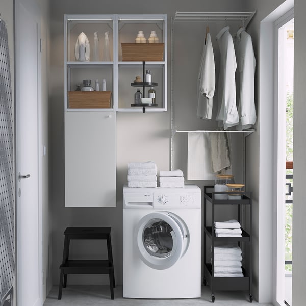 Configuración de lavandería compacta: lavadora ENHET, armario de pared, barra para colgar, estantería, taburete.