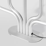 Moderna base de lámpara de mesa plateada con diseño elegante y curvo y cable de alimentación.