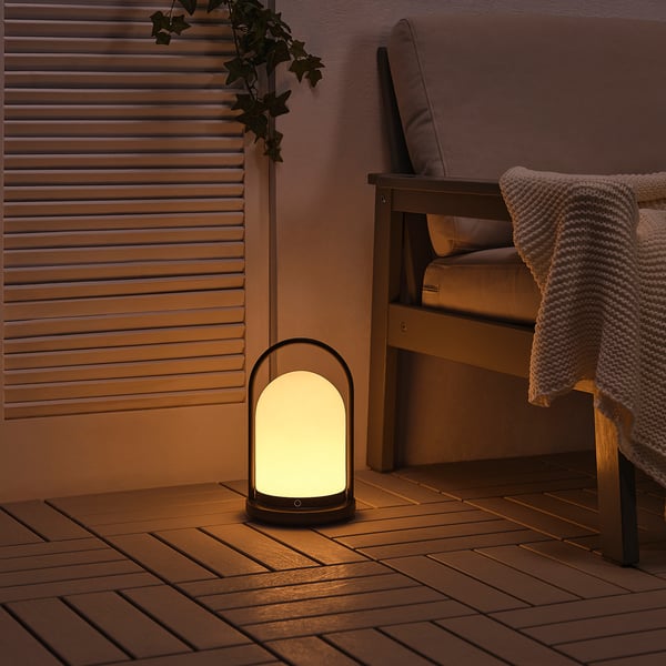 Acogedora linterna en un patio, que emite una luz cálida desde un led en forma de cúpula.