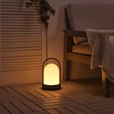 Acogedora linterna en un patio, que emite una luz cálida desde un led en forma de cúpula.