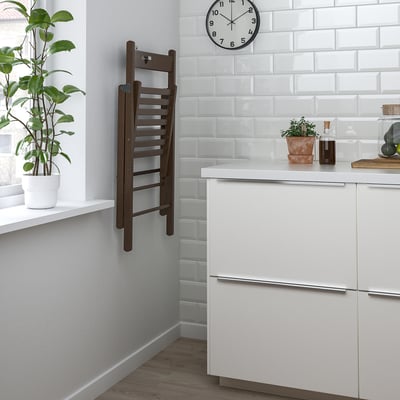 Una silla plegable de madera marrón de IKEA FRÖSVI con asiento y respaldo de láminas.