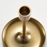 Candelabro dorado con tres soportes, diseño elegante y atemporal. Refleja la luz, creando un ambiente cálido y acogedor.