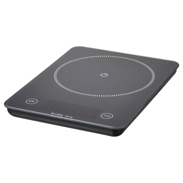 Una báscula de cocina digital GENOMSNITT, negra, con tapa cuadrada de cristal y pantalla digital.