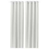 La imagen muestra cortinas blancas GINSTMOTT con ojales, diseño simple y elegante, hechas de poliéster reciclado para mayor sostenibilidad y privacidad.