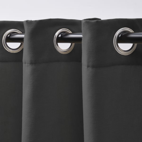 Representa cortinas de color gris oscuro con ojales metálicos, ideales para facilitar el deslizamiento sobre varillas. Estas cortinas dejan pasar la luz y ofrecen privacidad.