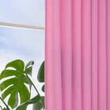 Cortinas de color rosa brillante cuelgan de una ventana, enmarcando una exuberante planta verde con hojas grandes, lo que permite que la luz diurna filtrada ilumine suavemente la escena.