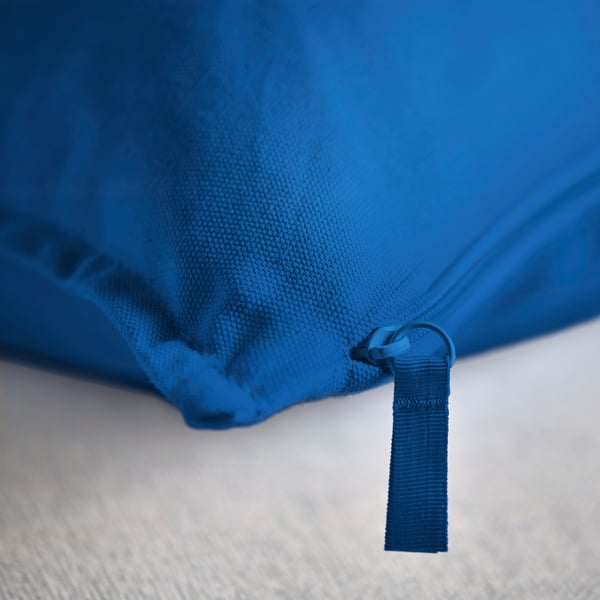 Cojín azul brillante con detalle de cremallera de calidad, que muestra material de algodón duradero.