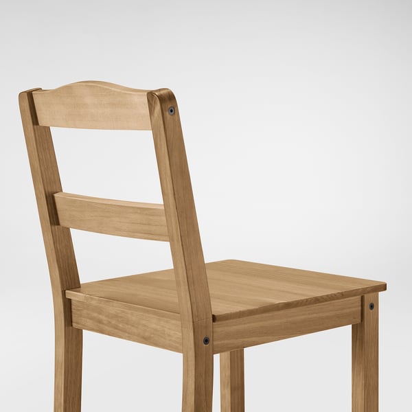 Una robusta silla de madera con acabado marrón claro, con un diseño de respaldo de escalera, sobre un fondo liso.