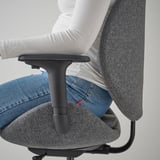 Persona sentada en una silla de oficina HATTEFJÄLL gris, mostrando un mecanismo de inclinación sincronizado en acción.