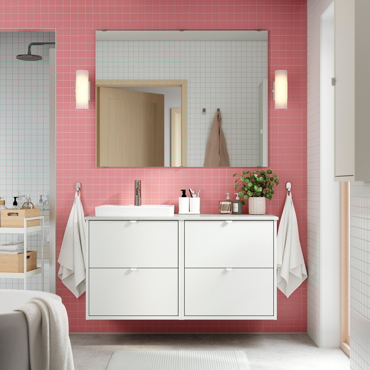 Moderno baño con azulejos rosas con tocador HAVBÄCK, espejo y toallas.