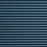 Persiana celular de rayas azules que oscurece la habitación, con patrones horizontales, textura visible, montada en la pared o el techo, creando una cálida privacidad.