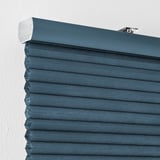 Primer plano de persianas de nido de abeja azules montadas en la pared, que muestran celdas que bloquean la luz y cordón oculto para mayor seguridad.