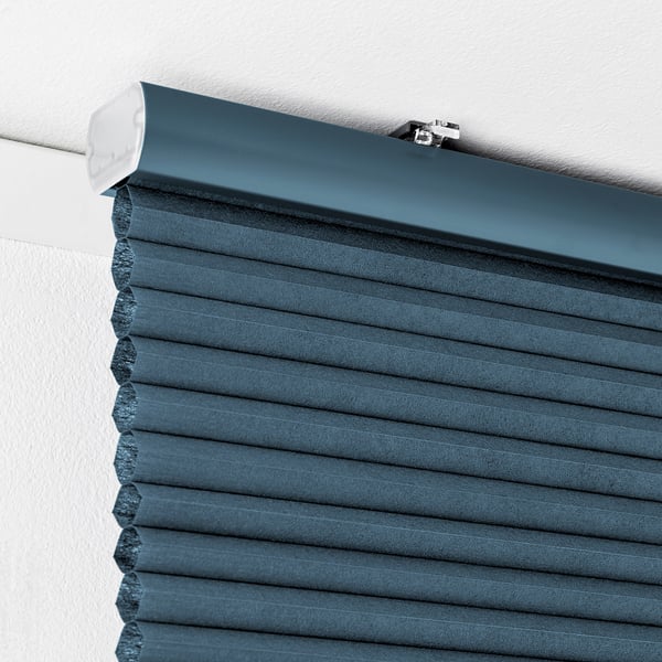 Pantalla de nido de abeja azul en pared blanca, se muestra el seguro del cordón.