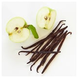 La imagen muestra mitades de manzana verde y vainas de vainilla sobre fondo blanco.