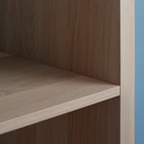 Primer plano de la estantería de vetas de madera marrón claro KALLAX de ikea, bordes lisos.