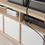 Banco de tv de madera con compartimentos abiertos. Sistema de gestión de cables visible en la parte trasera.