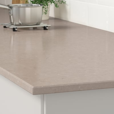 Una encimera de cocina moderna hecha de cuarzo duradero y resistente a las manchas, que muestra su superficie elegante y fácil de limpiar.