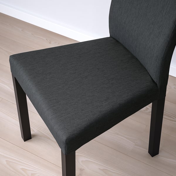 Silla cómoda y moderna de color gris oscuro en primer plano, que muestra elegantes patas negras y tela acogedora.