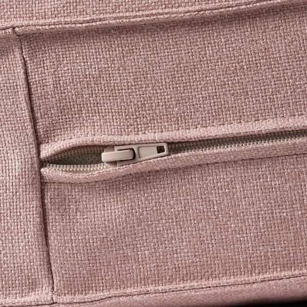 Primer plano de un bolsillo de sofá de tela tejida rosa con cremallera, que muestra una textura y un detalle de calidad.